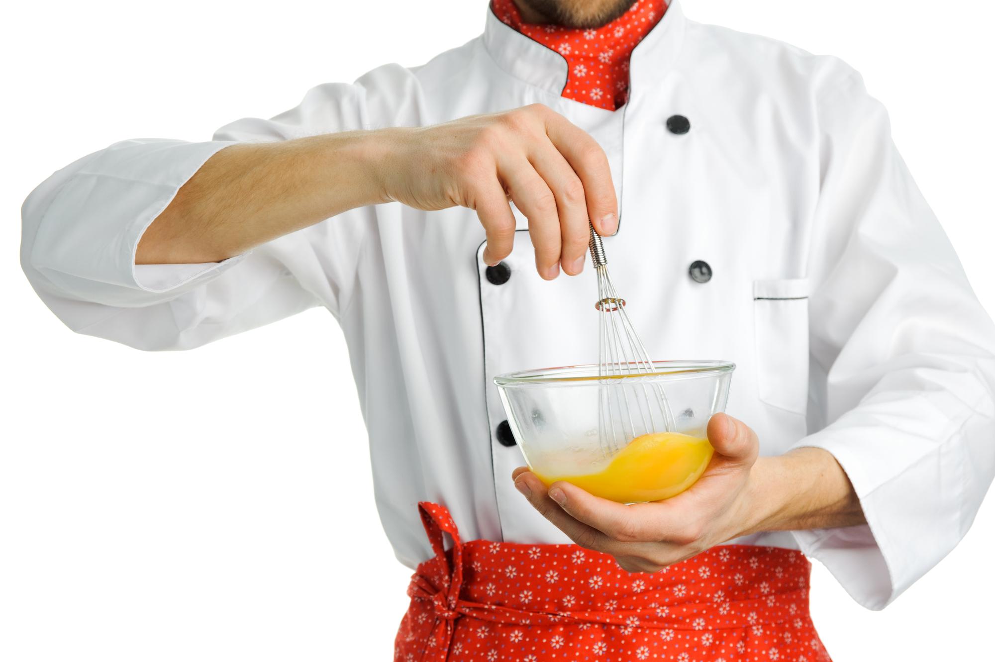 Chef che filtra salsa in cucina elegante